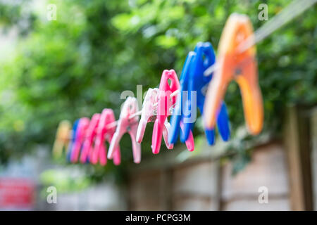 colourful plastic clothes pegs on a line Stock Photo