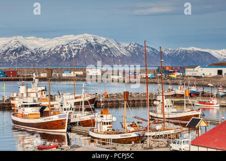 13 April 2018: Husavik, North Iceland - Whale watching boats in the harbour on a bright spring day.