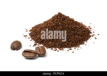 Heap of ground coffee and some beans isolated on white background Stock Photo