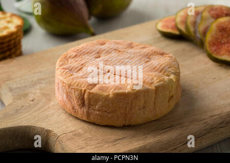 Whole ripe petit Munster cheese close up and fresh figs on the background for dessert Stock Photo