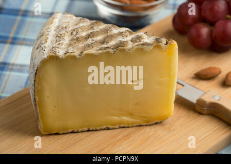 French Tomme de Montagne cheese on a cutting board as dessert Stock Photo