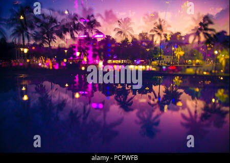 Abstract multiple-exposure defocused view at dusk of palm trees and neon lights of Ocean Drive reflecting in puddle at dusk in South Beach, Miami, Flo Stock Photo