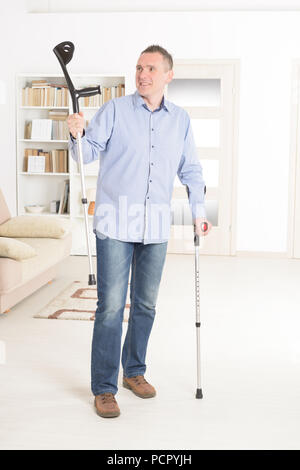 Man  with crutches, rehabilitation after injury Stock Photo