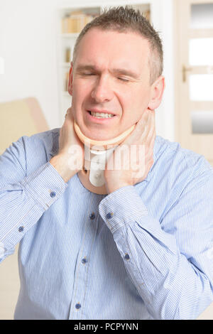 Man with a surgical cervical collar suffering from neck pain Stock Photo