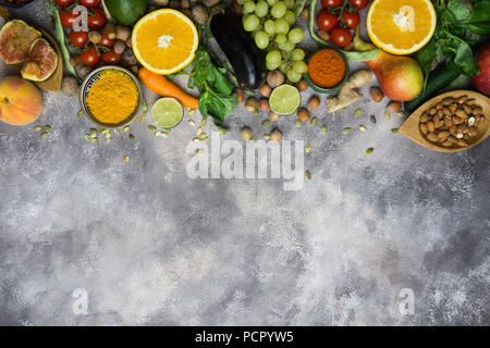 Healthy food background, frame of organic food. Ingredients for healthy cooking: vegetables, fruits, nuts, spices. Balanced diet food on a dark black Stock Photo