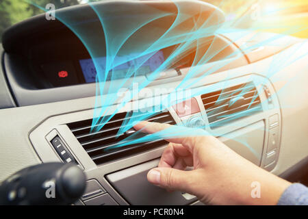 Driver hand tuning air ventilation grille, fresh air is coming out Stock Photo