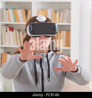 Woman using virtual reality headset to fight her phobias or fears at home Stock Photo