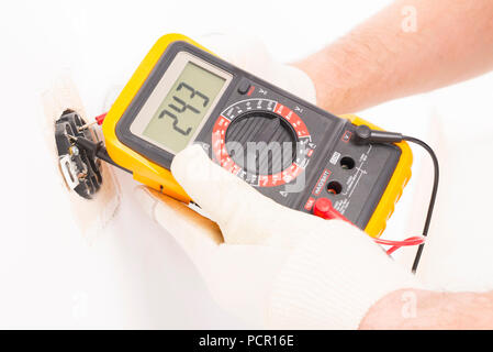 Electrician checking socket voltage with digital multimeter Stock Photo