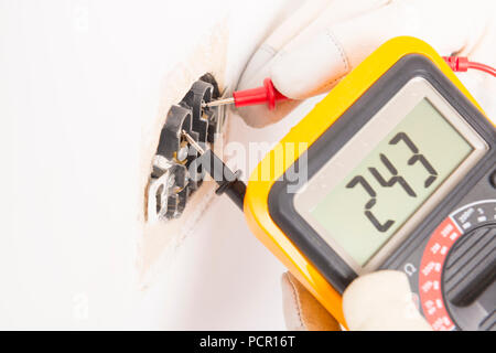 Electrician checking socket voltage with digital multimeter Stock Photo