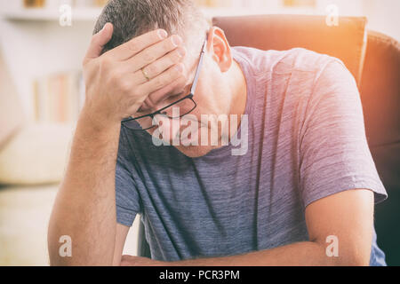 Tired man sitting at home office Stock Photo