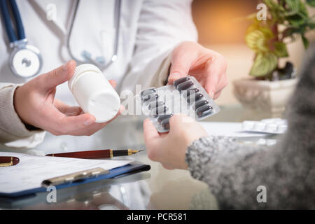 Doctor showing medicines to her patient in the doctor's office Stock Photo