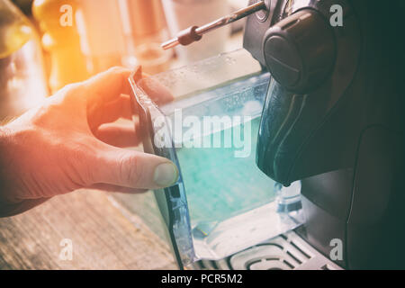 Water refill in coffee machine, a container in hand Stock Photo