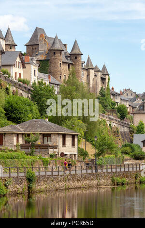 FRANCE, UZERCHE - JULY 12, 2018: A couple walking next to the river Vezere in the  picturesque medieval village. Stock Photo