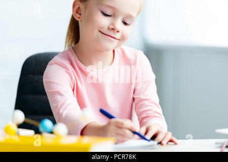 cropped shot of cute smiling schoolgirl taking notes Stock Photo