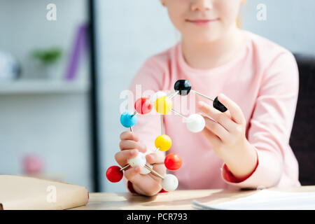 cropped shot of smiling schoolchild holding molecular model Stock Photo