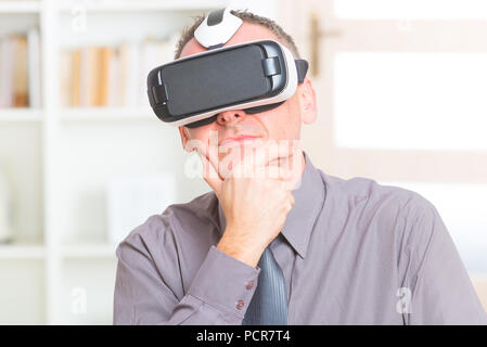 Businessman using virtual reality headset at the office Stock Photo