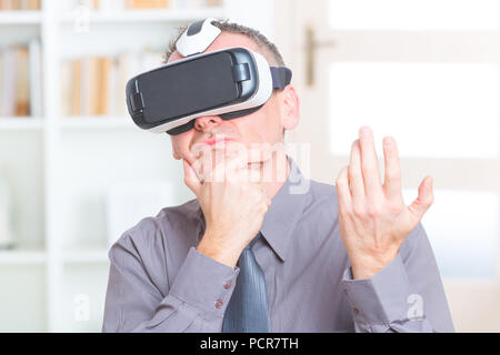 Businessman using virtual reality headset at the office Stock Photo