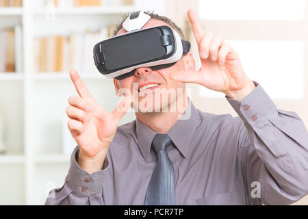 Businessman using virtual reality headset at the office Stock Photo