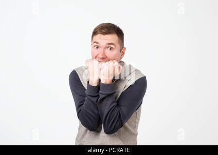 European man covering his mouth with both hands, looking shocked. Surprised, embarrassed and confused young male showing omg emotion Stock Photo