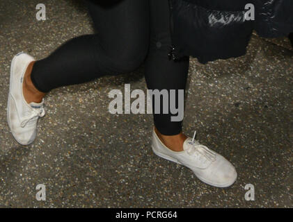 LOS ANGELES, CA - JULY 03: Ariana Grande was feeling coy and maybe a bit  embarrassed as she arrived in LA looking dirty wearing scuffed up white  sneakers and a scuffed up