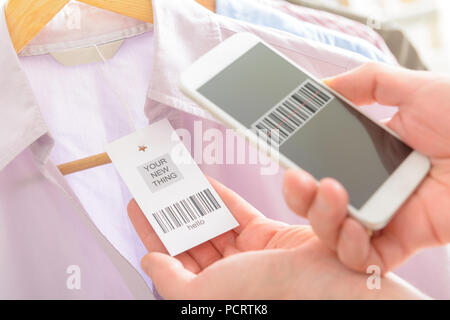 Woman scanning barcode from a label in a shop with mobile phone Stock Photo