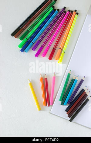 Accessories for children's art pencils, markers and album on a white background. Selective focus. Stock Photo