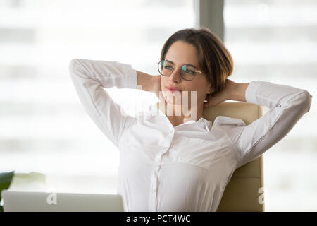 Thoughtful businesswoman leaning in chair relaxing after work Stock Photo
