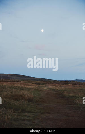 Moon appearing on a summer's evening over the Llyn Peninsula, North Wales, UK Stock Photo