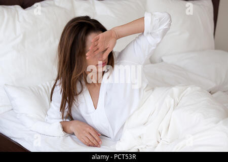 Sleepy millennial woman suffering from bad sleep waking up Stock Photo
