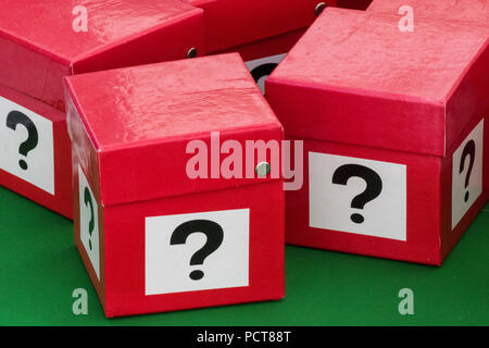 a number of red boxes painted with a question mark on each side. guessing what is in the secret box. lottery and gambling. Stock Photo