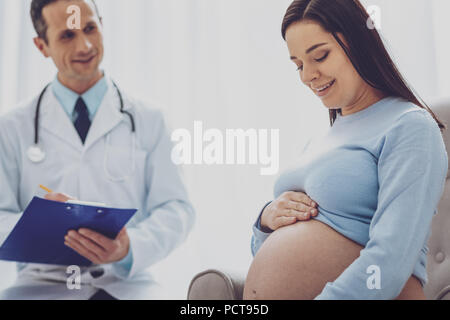 Joyful brunette sitting in semi position Stock Photo