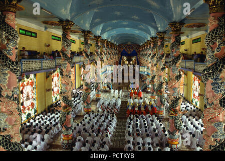 People praying in Cao Dai temple, Tay Ninh, Vietnam, Indochina Stock Photo
