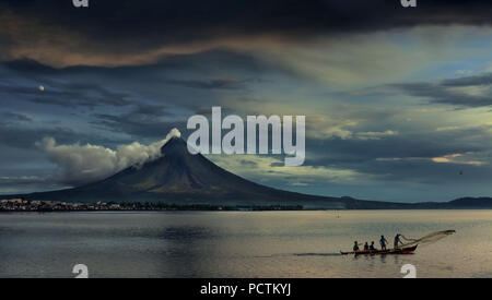 fishermen on outrigger in front of steaming Mayon Volcano, Legazpi City, Luzon Island, Philippines, Asia Stock Photo