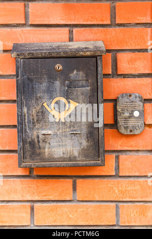 Old black mailbox on the wall of red brick. Stock Photo