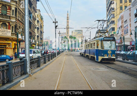 ALEXANDRIA, EGYPT - DECEMBER 18, 2017: The vintage trams look great among historical mansions of Mahta al Raml square, on December 18 in Alexandria. Stock Photo