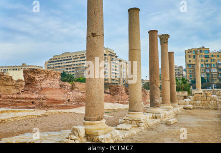 The ancient street of Kom Ad Dikka archaeological site with tall stone columns and ruined walls of Roman baths, Alexandria, Egypt. Stock Photo