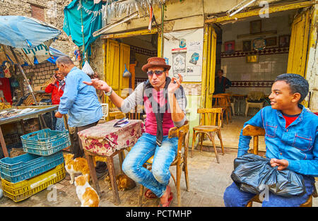 ALEXANDRIA, EGYPT - DECEMBER 18, 2017: The outdoor terrace of the old teahouse with visitors, drinking tea and watching passersby in the market street Stock Photo