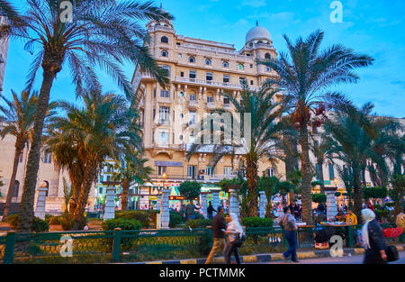 ALEXANDRIA, EGYPT - DECEMBER 17, 2017: The palm garden on Ahmed Oraby square with splendid building of former Majestic Hotel, on December 17 in Alexan Stock Photo