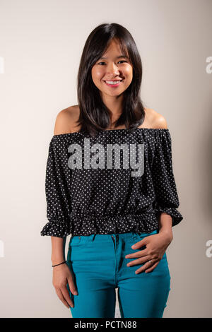 Beauty portrait of asian woman in a black and white polka dot shirt and blue jeans Stock Photo