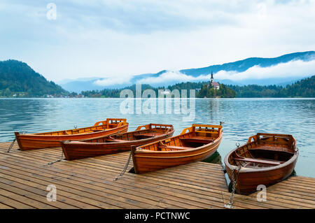 Boats on Bled lake, Slovenia. Mountain lake with small island and church. Mountains in the background. Stock Photo