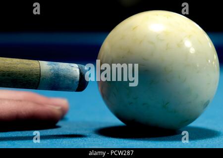 Macro of the tip of a pool cue just before striking the cue ball on a pool table Stock Photo