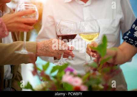 Senior friends cheering with wine glasses at home lunch - Happy mature people having fun together - Focus on left bottom glass - Joyful elderly lifestyle concept Stock Photo