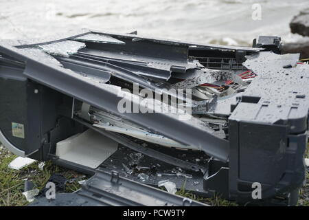 Man breaks a hammer system unit computer. Man with a sledge hammer and destroys computer in slow motion, river and forest background. Concept of confrontation between nature and technological progress. Stock Photo