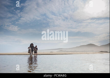 Hikers walking on the beach with backpacks on Tsitsikamma Hiking Trail, Tsitsikamma Mountains, Eastern Cape Province, South Africa Stock Photo