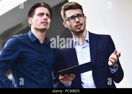 Make a decision Two caucasian businessmen talking about a project. Serious conversation Stock Photo
