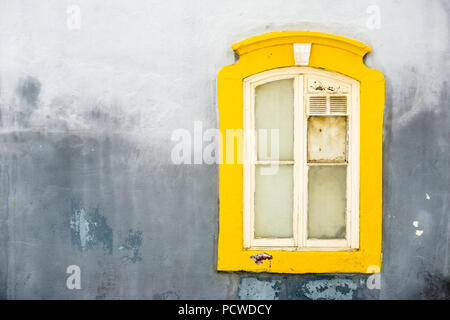 Old wooden window decorated with yellow frame, Portugal Stock Photo