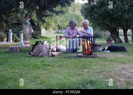 Happy couple enjoys the romantic evening at the campfire Stock Photo