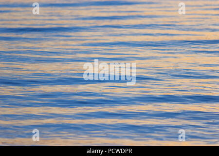 close-up texture of water, bronze waves at sunset Stock Photo