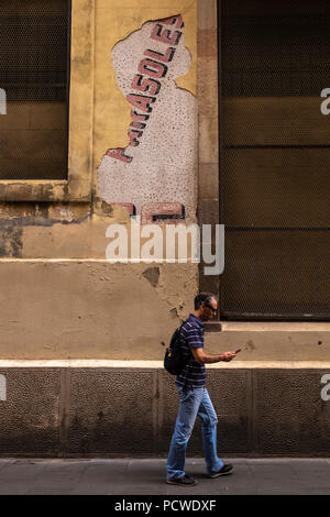 Peeling plaster reveals the word Parasoles on a wall in Carrer Valldonzella, Barcelona, Spain Stock Photo