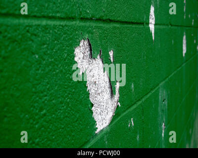 Close up of green paint peeling off of brick wall in multiple spots  Stock Photo